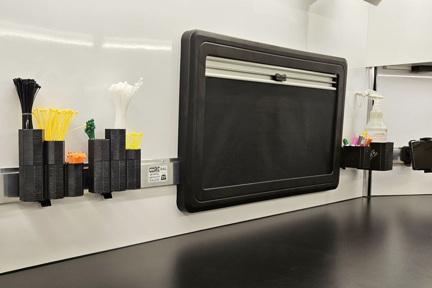 Interior view of a CORE PRO trailer highlighting the CORE Rail mounting system. Featuring zip-tie holders, cup holders, and our screen/shade windows as well