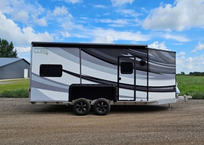 Exterior curbside view of the CORE RV 8022 with black and grey swooped graphics and awning