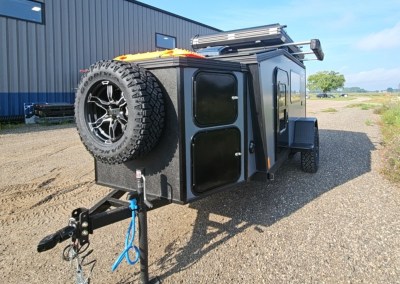 Exterior view of the CORE RV 5510 front insulated storage box with 2 lockable compartments and front spare mounted tire