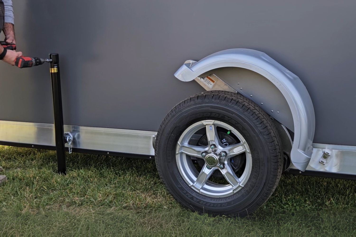 Woodgrain flooring shown up close with a spear hole trimmed out and catch cover ice fishing holes in the floor